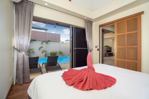 ラワイビーチにあるNew Boutique Pool Villa Sequoia Close to Rawai and Naiharn Beachのベッドルーム1室(赤いドレスのベッド1台付)