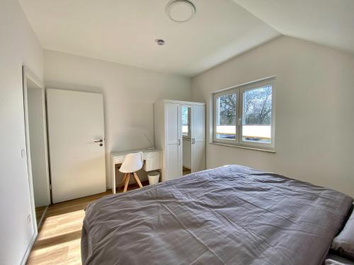 Un dormitorio con una cama grande y una ventana en Seeglück 1 am Tollensesee, en Groß Nemerow