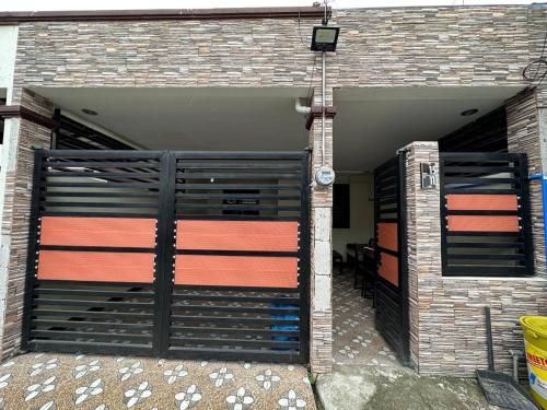 een garage met twee poorten en een stenen muur bij Casa Mercado lV in Lipa