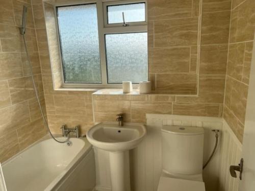 y baño con lavabo, aseo y bañera. en 3 bedroom mid terraced house (2 double & 1 single), en Grays