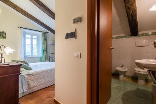 uma casa de banho com uma cama e um lavatório num quarto em Country House Le Marche em Monte San Pietrangeli