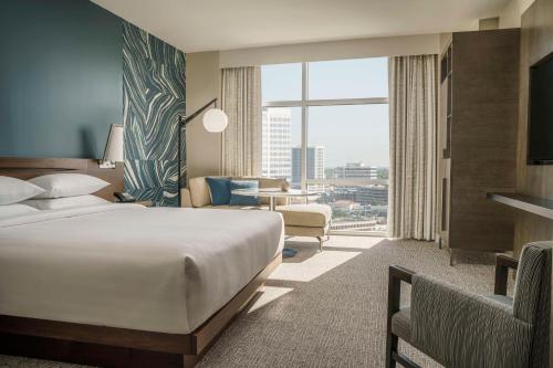 ヒューストンにあるハイアット リージェンシー ヒューストン ガレリアのベッドと大きな窓が備わるホテルルームです。
