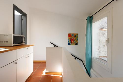 uma escada numa cozinha com um micro-ondas e uma janela em Lets Holidays COZY HOUSE in the CENTER of TOWN em Tossa de Mar