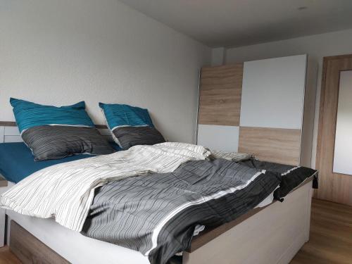 1 dormitorio con 1 cama grande con almohadas azules en Dorfidyll 