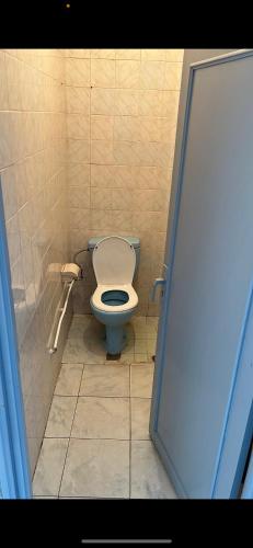 bagno con servizi igienici blu in una cabina di Kornich a Nador