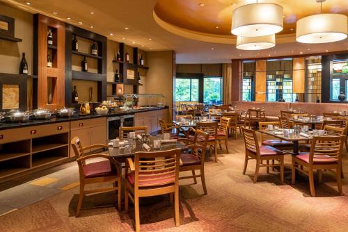 a restaurant with tables and chairs in a room at Hilton Alexandria Mark Center in Alexandria