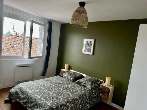 - une chambre avec un lit et un mur vert dans l'établissement Centre ville Dijon Wilson *Chez Charles* 2Ch, à Dijon