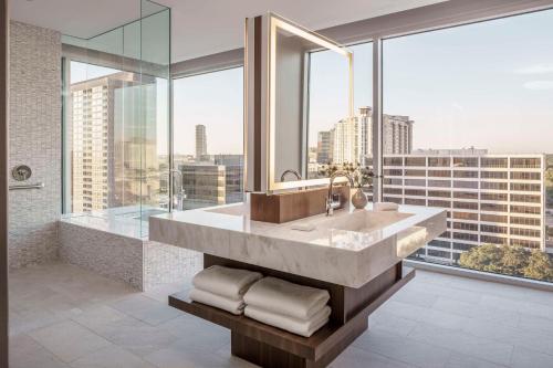 uma casa de banho com um grande lavatório e janelas grandes em Hyatt Regency Houston Galleria em Houston