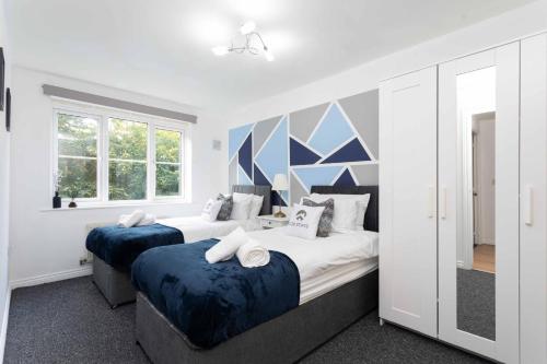 - une chambre avec 2 lits et une grande fenêtre dans l'établissement 30 Percent Off Monthly Stays - Free Parking - Sky & Netflix, à Borehamwood