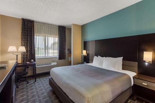 a hotel room with a large bed and a desk at Quality Inn Galesburg near US Highway 34 and I-74 in Galesburg