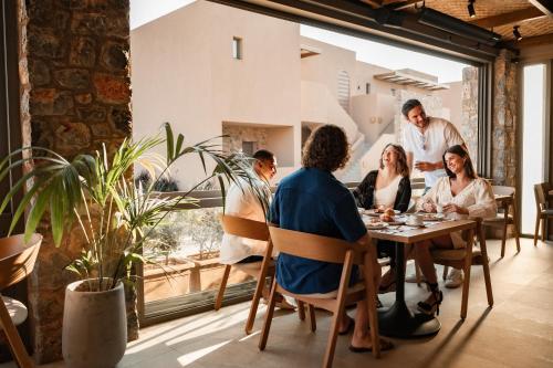 a group of people sitting at a table in a restaurant at Paralos Venus Suites Adults Only in Hersonissos