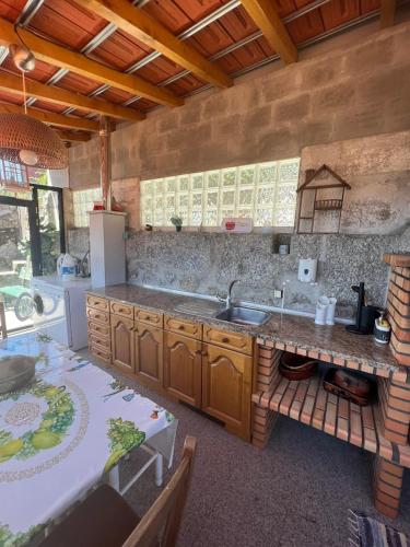 a large kitchen with a sink and a table at Casa do Pátio - Férias no Douro in Baião