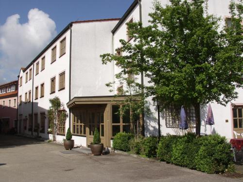 ein weißes Gebäude mit einem Baum davor in der Unterkunft Hotel zur Post Garni in Dietfurt