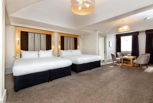 a hotel room with two beds and a table at DoubleTree by Hilton Harrogate Majestic Hotel & Spa in Harrogate