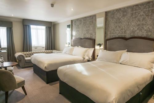 a hotel room with two beds and a couch at DoubleTree by Hilton Harrogate Majestic Hotel & Spa in Harrogate