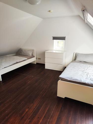 - une chambre avec 2 lits et du parquet dans l'établissement Großzügige Unterkunft, à Oldenbourg