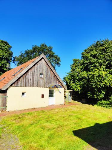 une ancienne grange sur une pelouse avec des arbres dans l'établissement Großzügige Unterkunft, à Oldenbourg