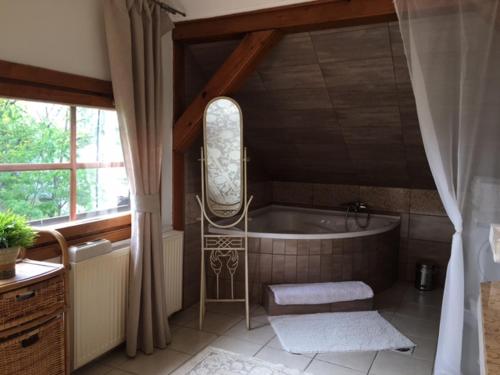 a bathroom with a bath tub and a window at SÓSTÓI UDVARHÁZ in Nyíregyháza