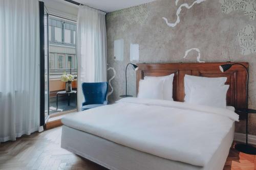 Un dormitorio con una gran cama blanca y una ventana en Story Hotel Riddargatan, part of JdV by Hyatt, en Estocolmo