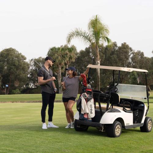 a man and a woman standing next to a golf cart at Radisson Blu Resort Saidia Beach in Saidia 