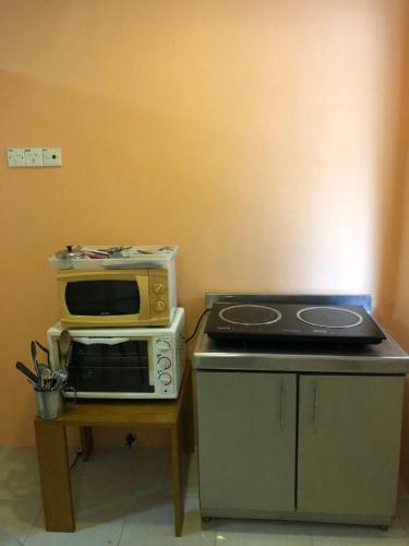 a kitchen with a microwave and a stove at Supreme Homestay in George Town