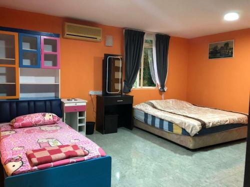 a bedroom with two beds and a television in it at Supreme Homestay in George Town