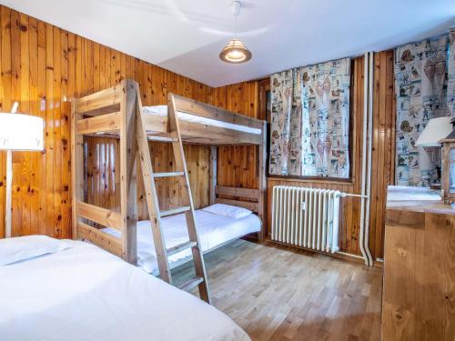 Ce lit se trouve dans un dortoir doté de 2 lits superposés et de murs en bois. dans l'établissement Appartement de charme centre ville, 6-7 pers, proche pistes et commerces, WiFi - FR-1-519-13, à Val dʼIsère