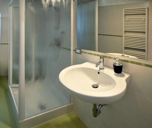 a white sink in a bathroom with a shower at Apartment Nido Stazione in Bergamo