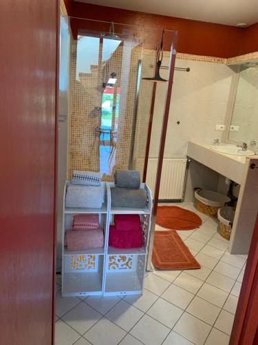 a bathroom with a sink and four towels at Maison cocoon avec jacuzzi privé vue Dordogne in Castillon-la-Bataille