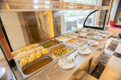 a buffet line with many different food items at Ramada by Wyndham Murree Lower Topa Resort in Murree