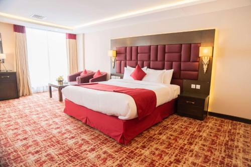 a hotel room with a large bed and a large window at Ramada by Wyndham Murree Lower Topa Resort in Murree
