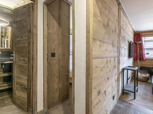 Cette chambre est dotée d'un mur en bois et d'une porte. dans l'établissement Appartement ski aux pieds, centre Val d'Isère, jusqu'à 6 pers, WIFI - FR-1-519-31, à Val dʼIsère