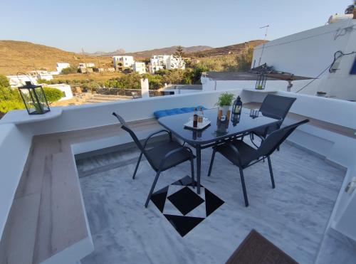 eine Terrasse mit einem Tisch und Stühlen auf dem Balkon in der Unterkunft Villa Anemona Tinos in Kalloni Tinou