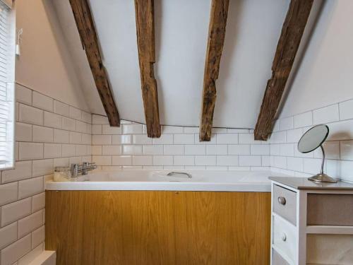 ein Badezimmer mit einem großen Waschbecken und Holzschränken in der Unterkunft Townhouse with cathedral views in Kent
