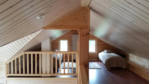 une chambre avec un escalier dans une maison en bois dans l'établissement Hallahaukka, à Ivalo