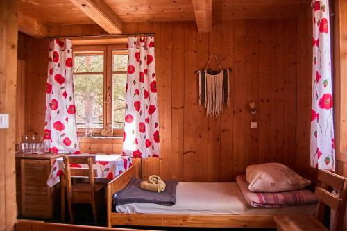 a bedroom with a bed in a wooden cabin at Folwark Toporzysko in Jordanów
