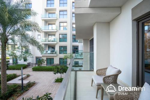 a balcony of a building with a chair and a palm tree at Dream Inn - Address Beach Residence Fujairah - Premium Apartments in Fujairah