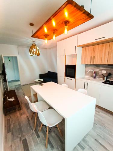 een witte keuken met een witte tafel en stoelen bij Preciziei Retreat Ap with parking and self check in in Boekarest