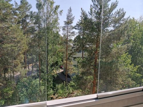 a view of a building through a forest of trees at Sun Apart Vuorenrinne in Kotka
