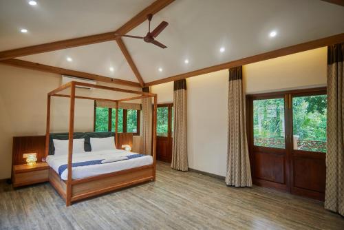 a bedroom with a canopy bed and windows at Tropical villa by Happyinch in Saligao