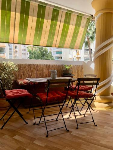 - une table et des chaises dans une chambre avec fenêtre dans l'établissement Habitación con Smart tv en piso compartido con baño privado o compartido Malaga Sol, à Malaga