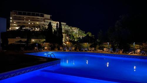 - une piscine de nuit avec un bâtiment en arrière-plan dans l'établissement Blue Senses 518, à La Vila Joiosa