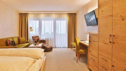クニービスにあるHotel Waldblick Kniebisのベッドとデスクが備わるホテルルームです。