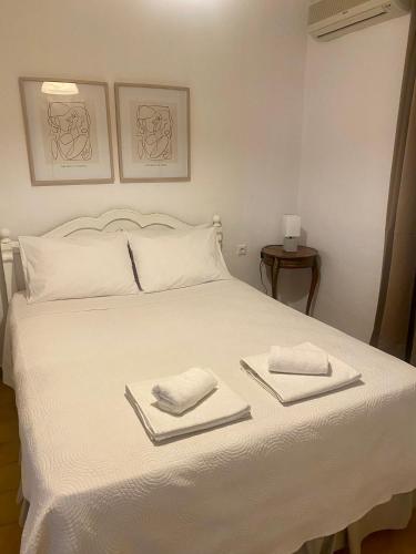 a white bed with two towels on top of it at Zante Star Summer House in Zakynthos Town