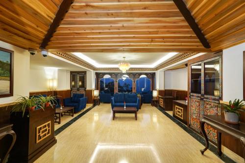 a waiting room with blue chairs and wooden ceilings at Denzong Regency- Luxury Mountain Retreat Spa & Casino in Gangtok