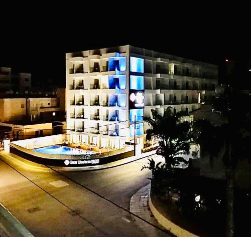 a building with a swimming pool in front of it at night at Mackenzie apartment 301 in Larnaca