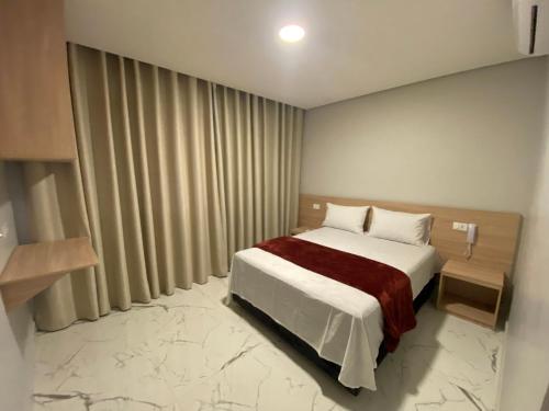 ein Schlafzimmer mit einem Bett und einem großen Fenster in der Unterkunft Hotel Fênix Belenzinho in São Paulo