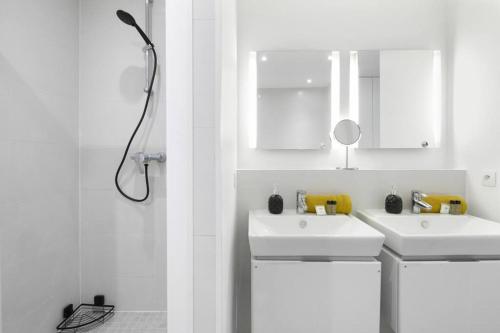 une salle de bain blanche avec deux lavabos et une douche dans l'établissement Sweet Luxury Home Arc the Triomphe near Champs Elysées and Palais des Congrès 8 ppl, à Paris