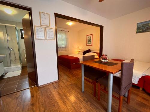 um quarto com uma mesa, uma cama e um espelho em Apartment & Room Monika em Rakovica
