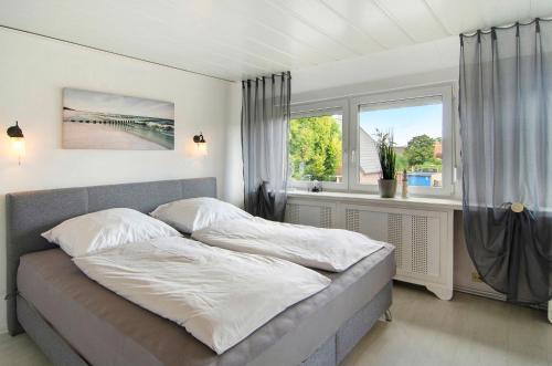 a bedroom with a large bed with a window at Fewo am Deich in Wilhelmshaven